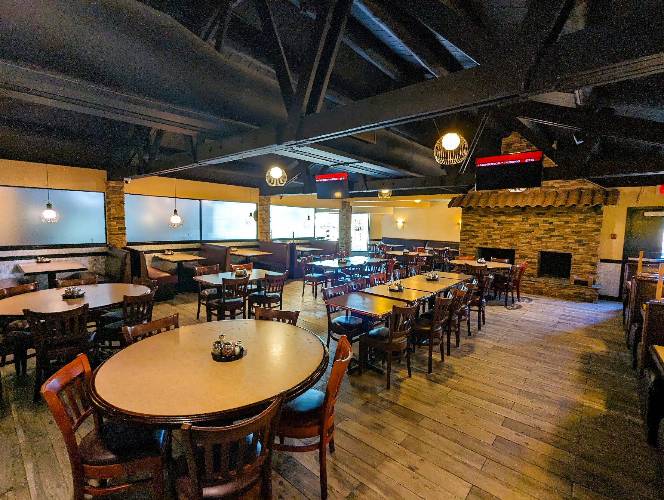 Warm, spacious dining room at Wood Fired Pizzeria with a stone fireplace