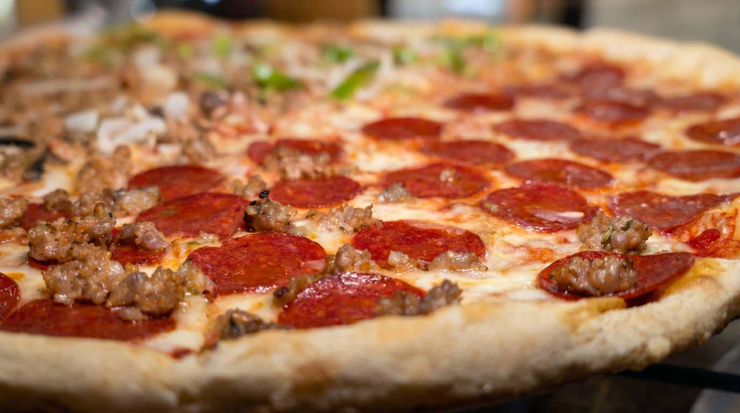 Close-up of a pepperoni and sausage pizza with golden crust